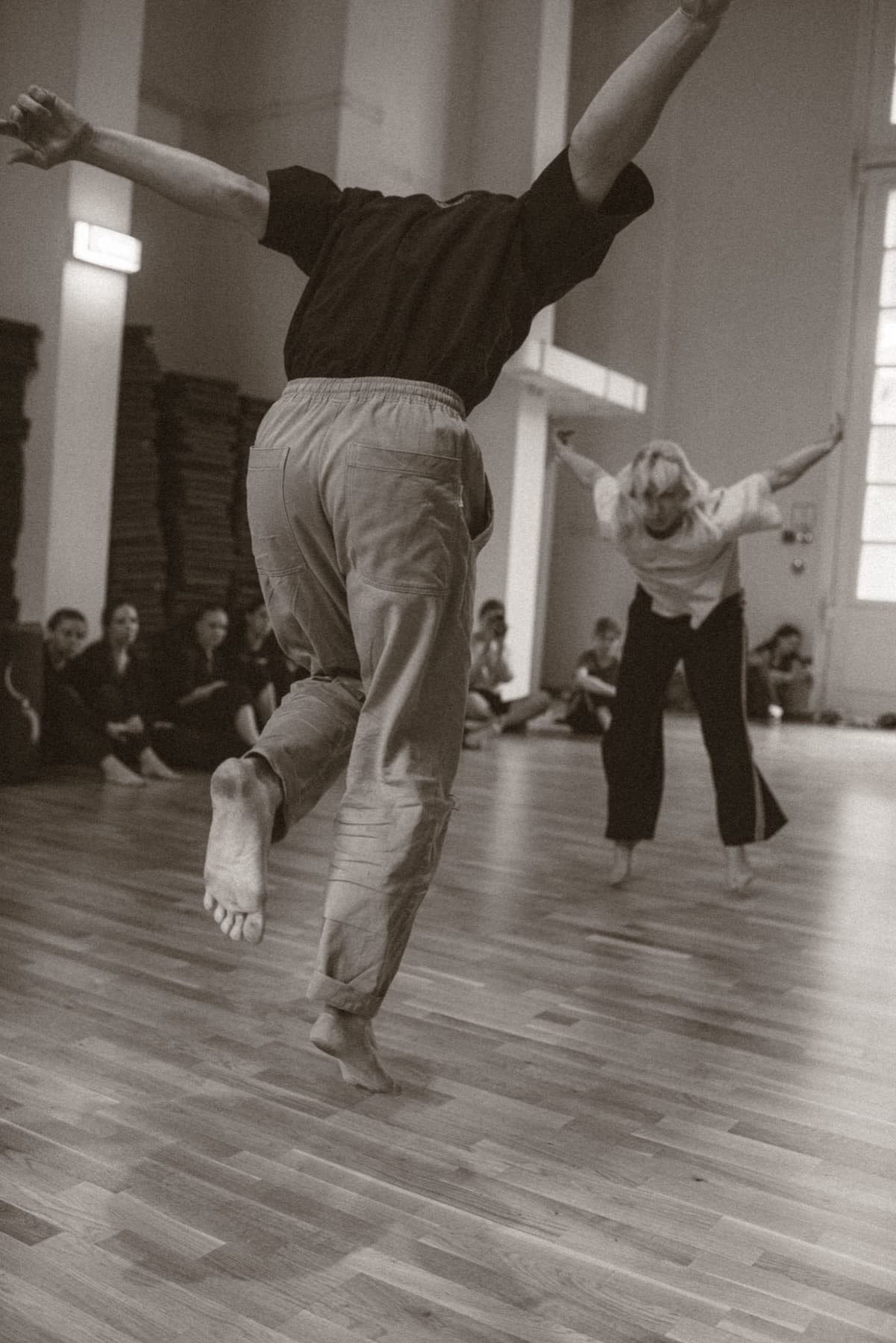 Two performers echo an open-armed movement during a Green Theatre laboratory while the group watches.