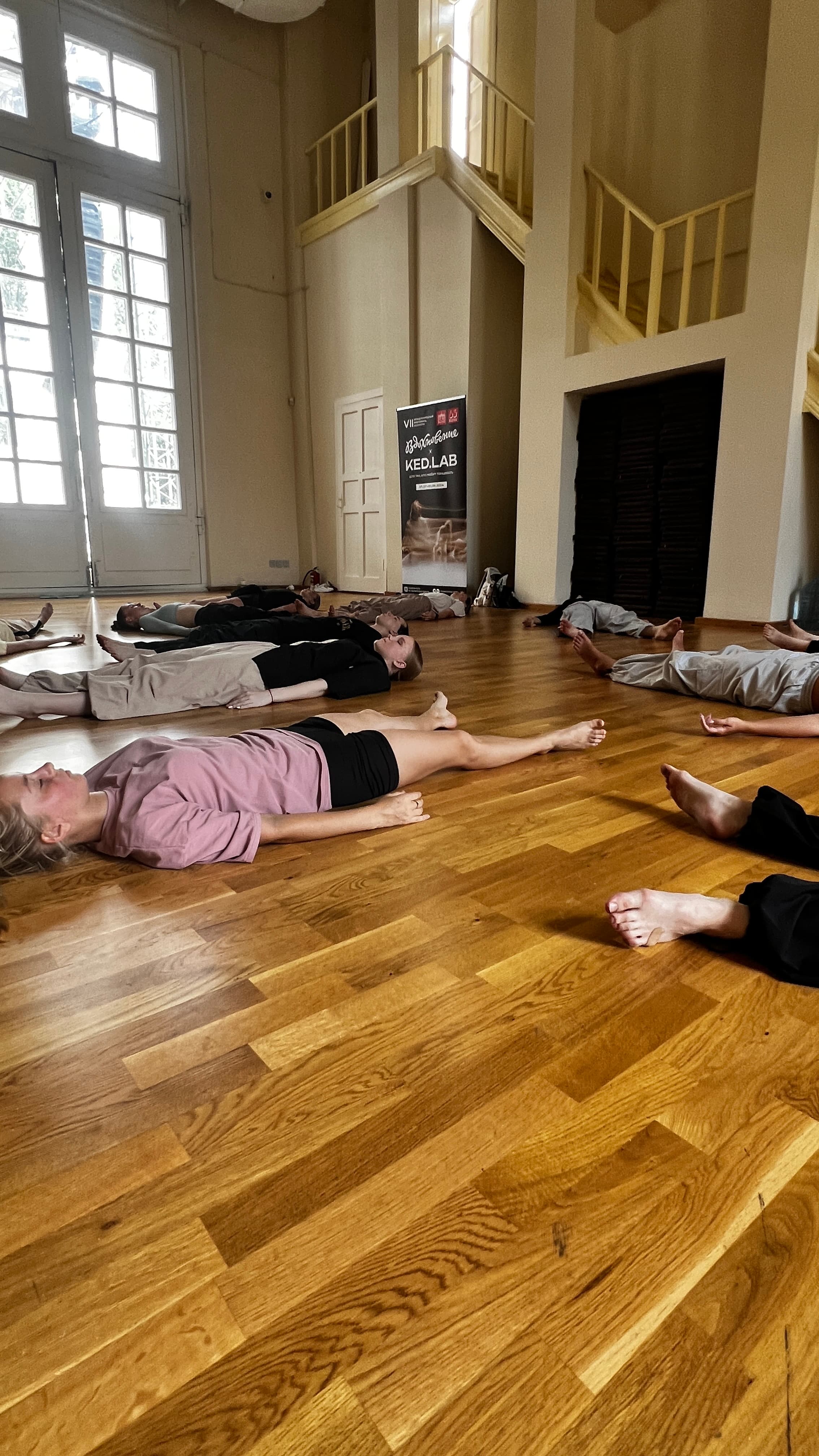 Participants lie in a circle on the studio floor during a Green Theatre laboratory.