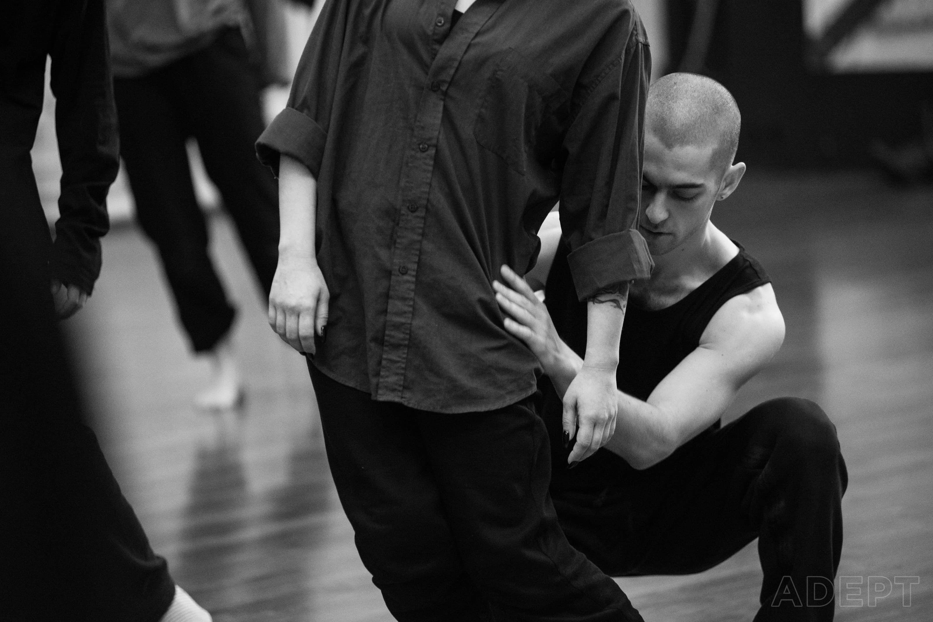 A facilitator supports a standing participant during a contact exercise.