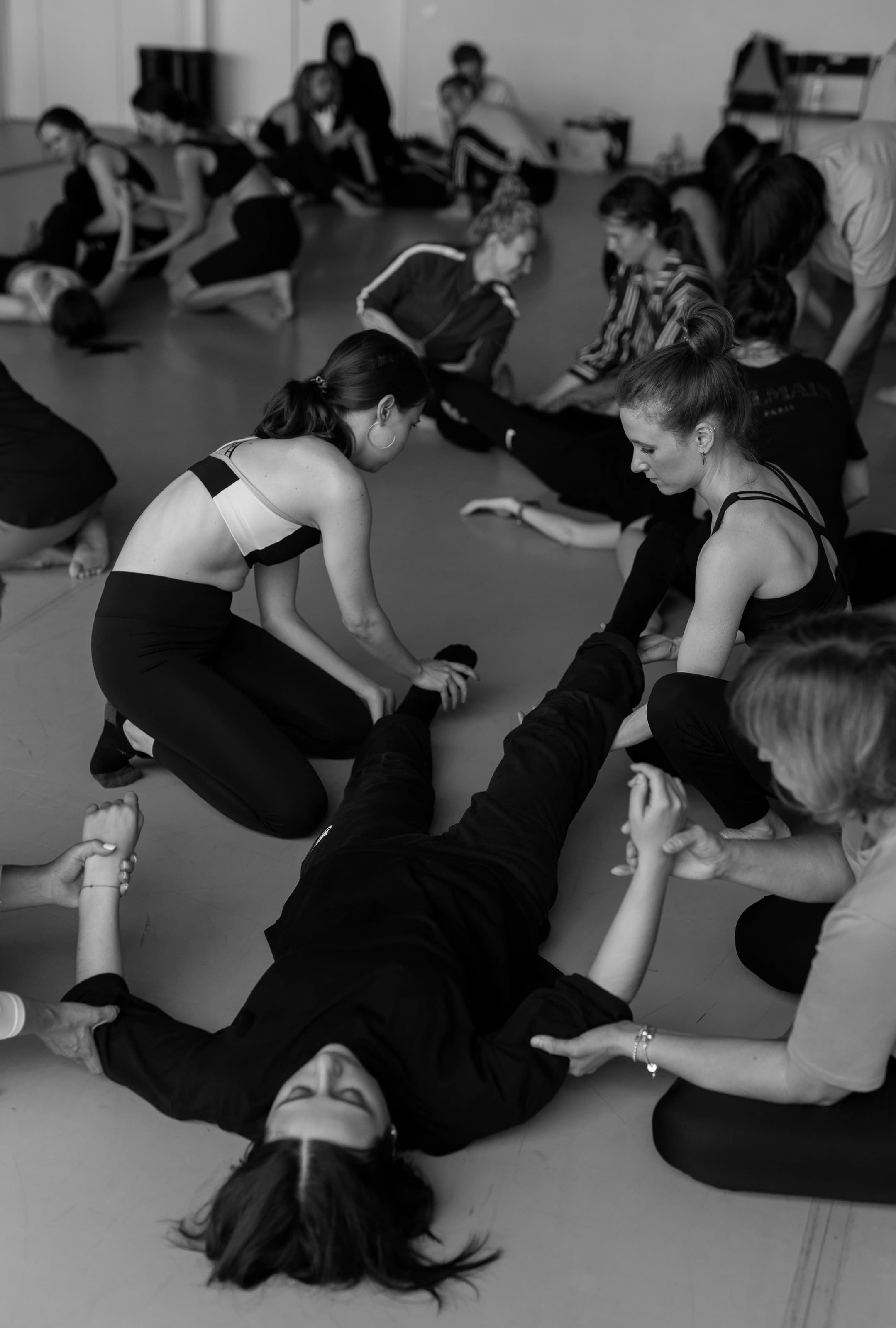 Participants work together on the studio floor in a black-and-white photograph.