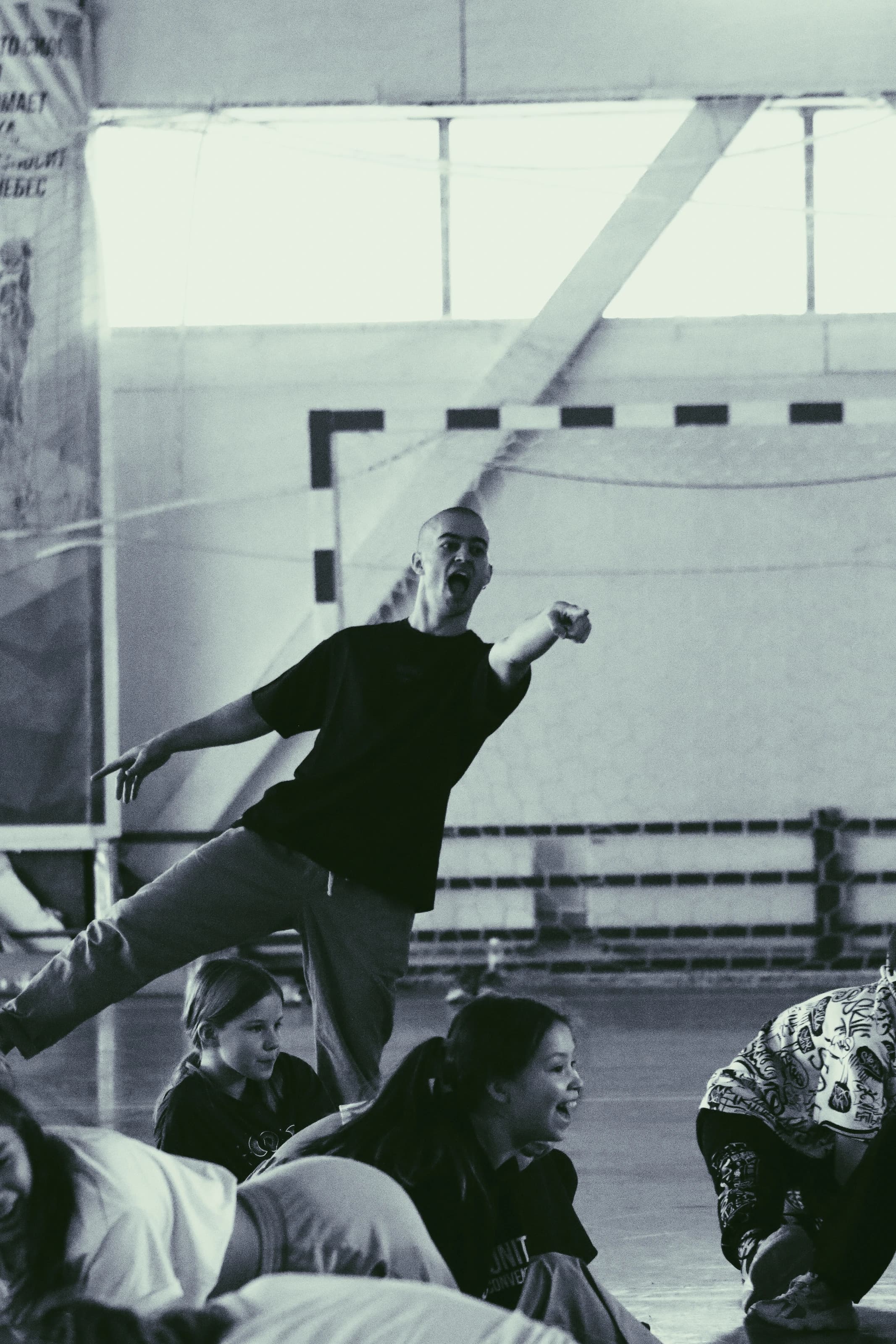Kolya Bagdasaryan moves among participants in a gymnasium.