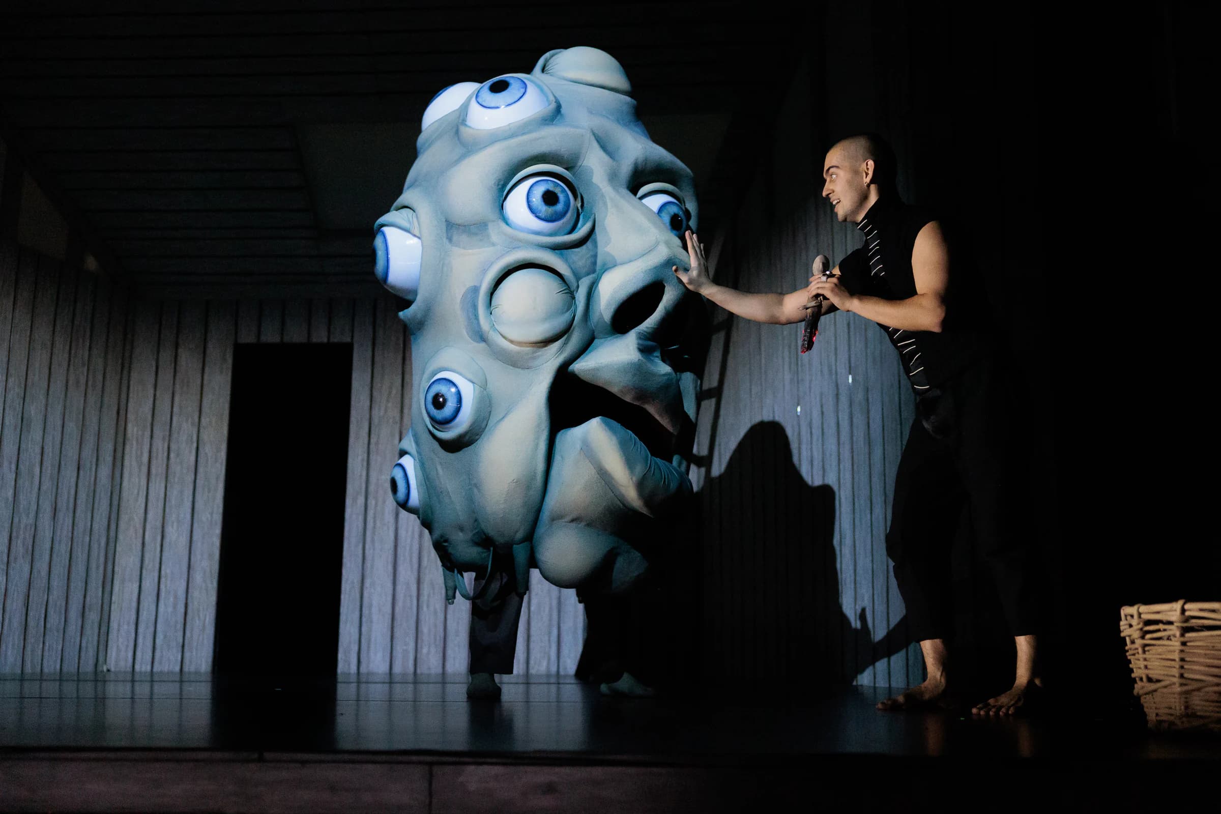 Mephistopheles encounters a large many-eyed figure on stage.