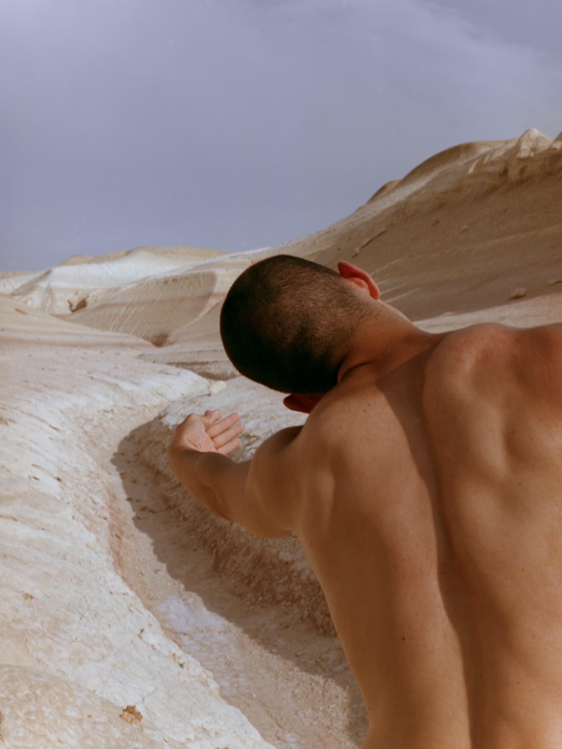 Kolya Bagdasaryan leaning back in a movement gesture against the pale Bozzhyra landscape.