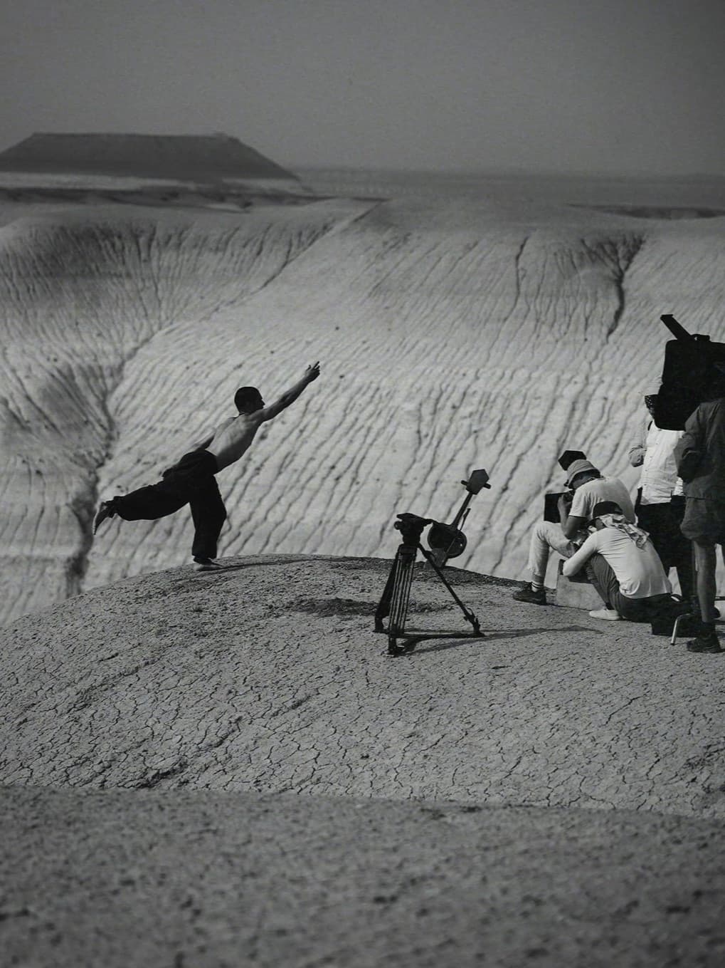 Backstage view of Kolya Bagdasaryan moving through the Bozzhyra landscape while a film crew records him.