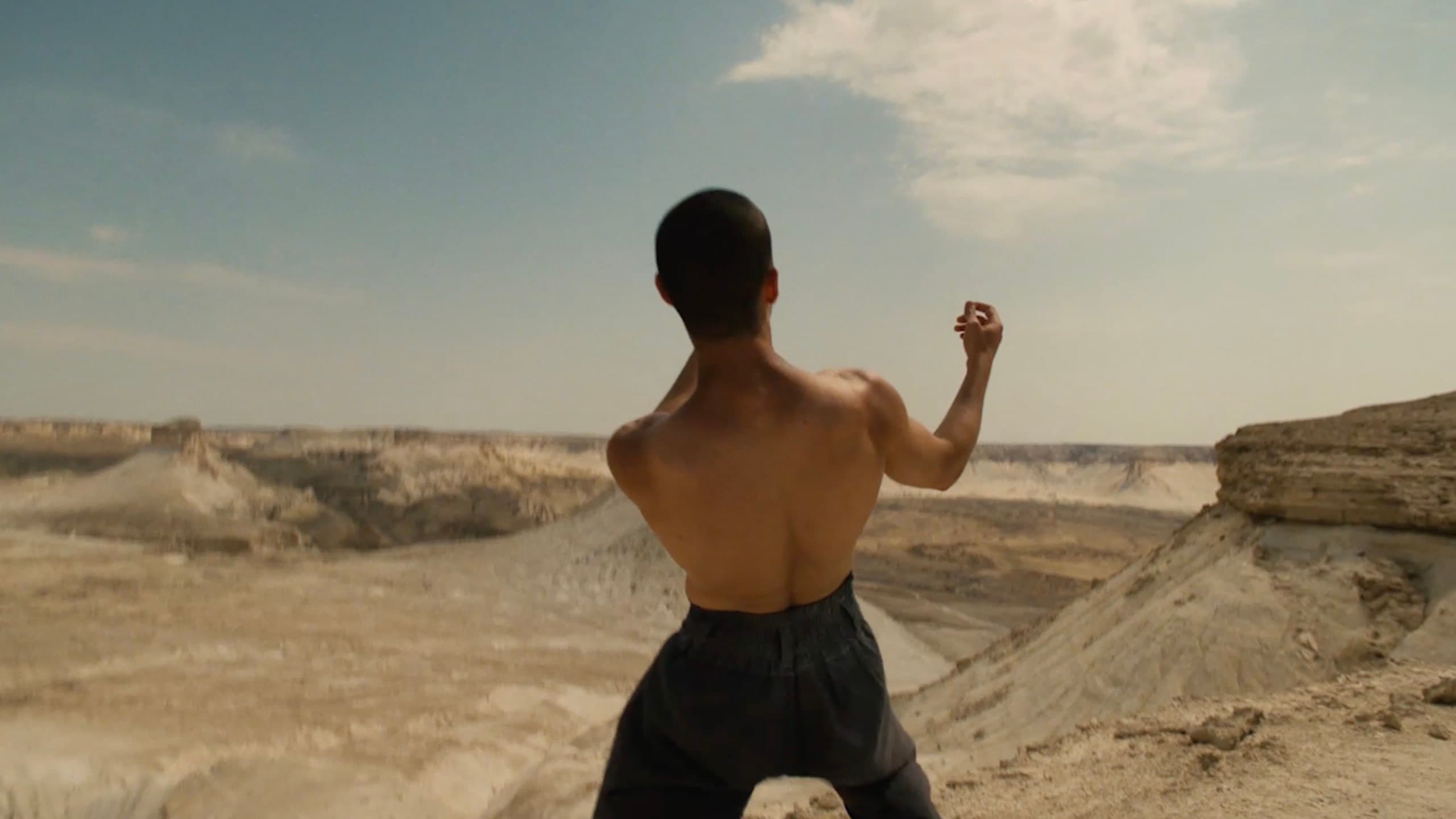 Kolya Bagdasaryan moving with his back to the camera in the Bozzhyra landscape.